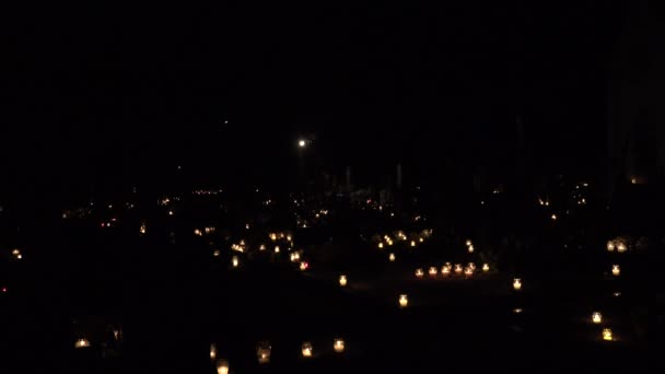 La gente visita tumbas en el cementerio en el día de todos los muertos en la noche . — Vídeos de Stock