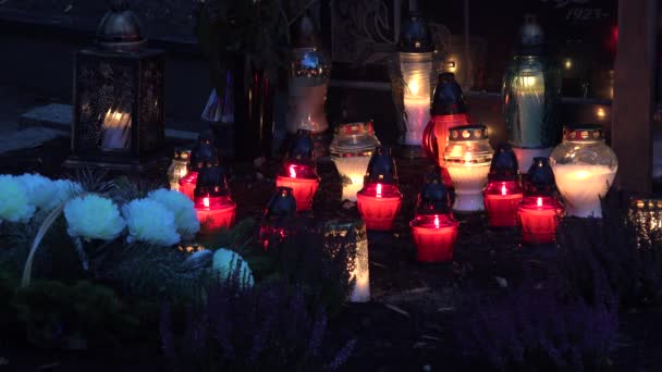 Großaufnahme einer Gruppe bunter Kerzen brennt auf Grab auf Friedhof. — Stockvideo