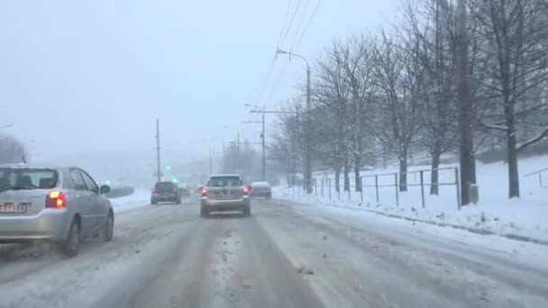 Automobily vozy jízdy na vozovce v sněhové bouři v městě. 4k — Stock video