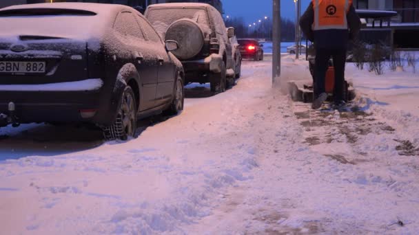 Hombre trabajando con una máquina de soplado de nieve en el distrito residencial de la casa plana. 4K — Vídeos de Stock