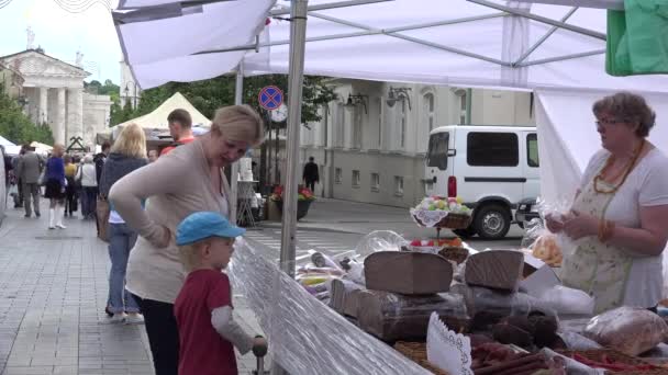 Μητέρα με παιδί αγοράσουν φρέσκο σπιτικό ψωμί ψημένο στην αγορά. 4k — Αρχείο Βίντεο