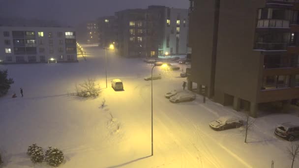 Människor i lägenhethus distrikt på tung snö faller blizzard. 4k — Stockvideo