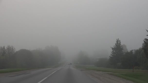 车开在雾中。秋天天气恶劣和危险的汽车在公路上。4 k — 图库视频影像