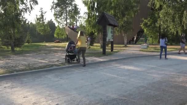 Madre conducir con carro de bebé. Edificio moderno en la naturaleza. 4K — Vídeos de Stock