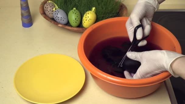 Las manos quitan la cáscara de huevo de Pascua pintada con tijeras. Pintura creativa — Vídeos de Stock
