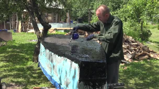 Hombre reparar barco viejo con resina negra quemador especial en el patio. 4K — Vídeo de stock