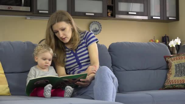 Donna e bambino bambino leggere libro insieme a casa . — Video Stock