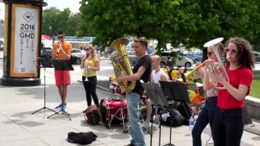 Öğrenci grubu rüzgar ile müzik çalmak ve şehir merkezinde aletleri davul.