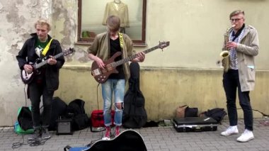 Genç sevimli karizmatik çocuklar sokakta enstrümantal müzik çalıyorlar..