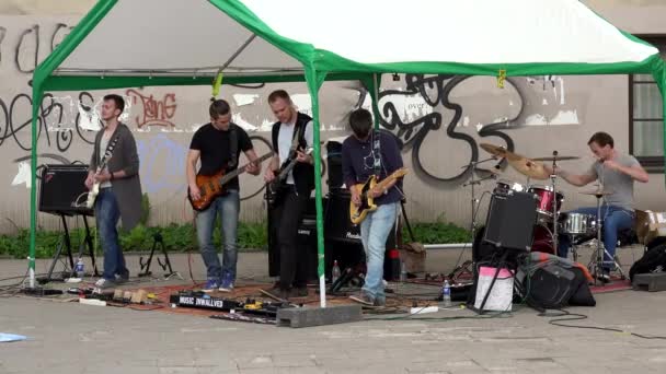 Men playing with electric guitar and drummer on street arbors roof — Stock Video