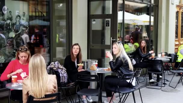Mensen meisjes genieten van een diner in outdoor café restaurant en man spelen piano — Stockvideo