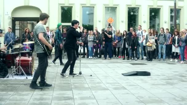 Gruppe junger Musiker musiziert und singt gegen Menschen. — Stockvideo