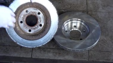 Mekanik uzman yıpranmış fren disk ve almak yeni bir değiştirme için gösterilen.
