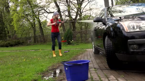 Ευτυχισμένος χαμογελαστό γυναίκα με μαντίλα πλύσιμο αυτοκινήτων αυτοκινήτου με εκτόξευση νερού. — Αρχείο Βίντεο