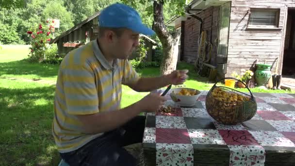 Homem limpo cogumelos chanterelle à mesa no quintal do país. 4K — Vídeo de Stock