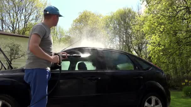 Hombre, la manguera de su coche en hacerlo usted mismo lavado de coches, el uso de pulverización de agua de alta presión — Vídeos de Stock