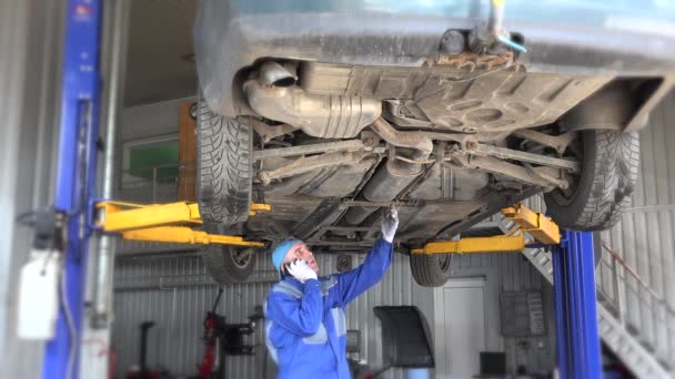 Parlare meccanico con il cliente al telefono in auto al garage di riparazione . — Video Stock