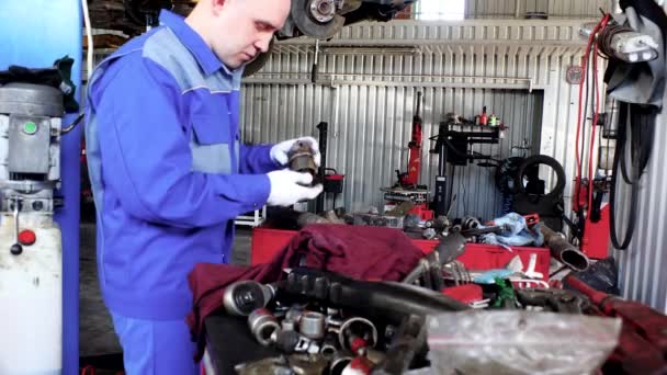 Ingenieur man verwacht gebruikte auto-onderdeel in garage. — Stockvideo