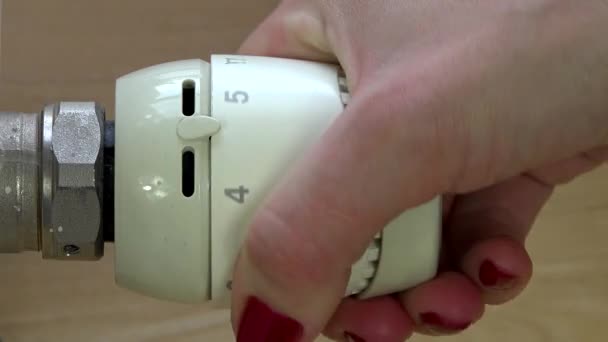 Close-up van de hand van een vrouw een radiator knop draaien van. — Stockvideo