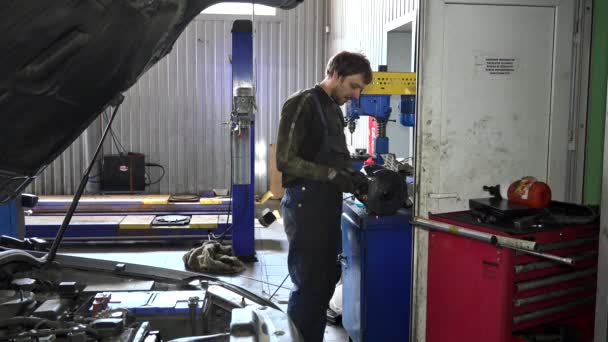 Mechanic guy polishing metal part on polishing machine — Stock Video