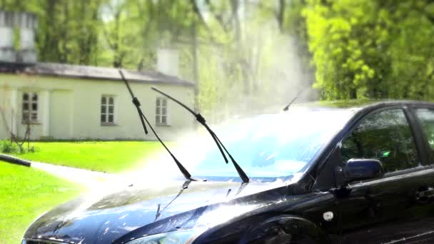 Worker washing automobile with high pressure water jet in house yard. — Stock Video