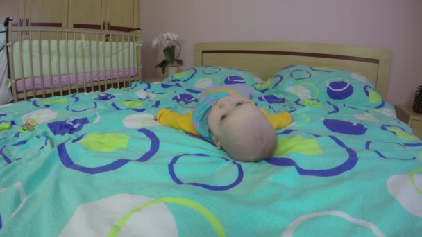 Schattige pasgeboren baby proberen beurt over zijn rug. 4k — Stockvideo