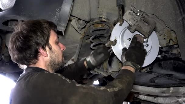 Чоловік ремонтує автомобільну гальмівну систему . — стокове відео