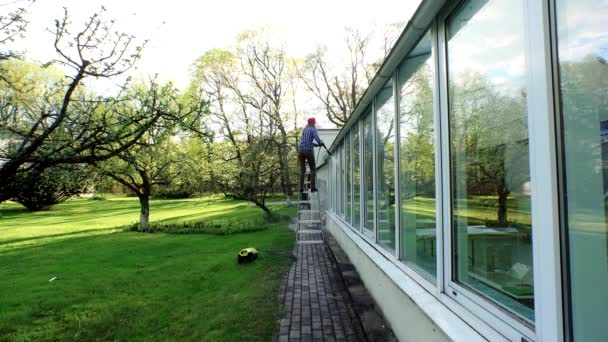 Schoonmaken van de buitenkant van het gebouw met hoge druk waterstraal meisje. — Stockvideo