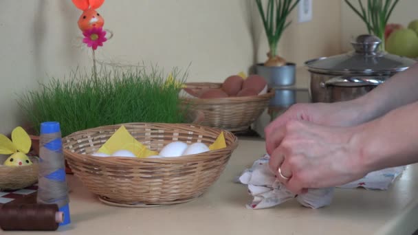 Le mani mettono l'uovo bianco in materiale e fanno bollire in pentola. Pittura uova di Pasqua . — Video Stock