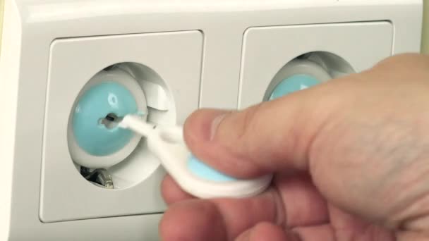 Hand remove safety plug from outlet and insert plug wire — Stock Video