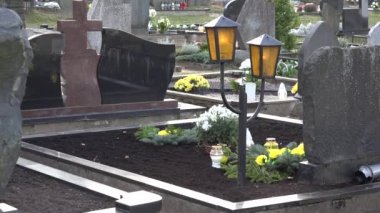 Üzgün dul kadın koca mezarlığındaki mezar mum koymak. 4k