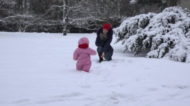 Kukla ile oynak anne bebek çocuk kışın karda yürümek için çekmek. 4k