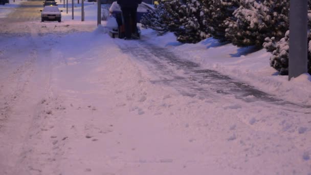 Człowiek z dmuchawa do śniegu czysty droga na zimowe ulic. 4k — Wideo stockowe