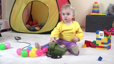 Eski yeşil telefonda konuşurken, anne deme küçük kıvırcık saçlı sarışın kız,.