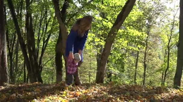 Mujer enseñar bebé niño caminando en el bosque de otoño. 4K — Vídeos de Stock