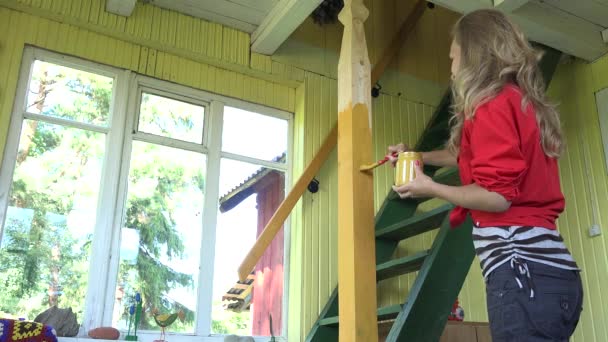 Menina mulher feliz com pincel pintando poste de madeira na sala de jardim rural. 4K — Vídeo de Stock