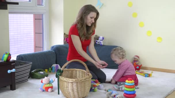 Jovem mãe e sua menina brincando junto com brinquedos em casa . — Vídeo de Stock