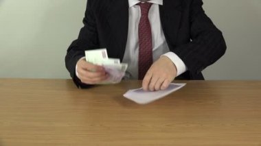 Erkek el euro banknot para masa üzerinde beyaz zarfa koy. 4k