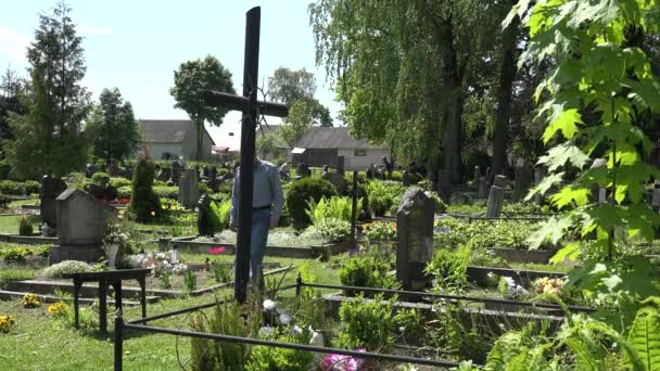 Veuf déprimé homme assis sur le banc près de la tombe de la femme dans la douleur. 4K — Video