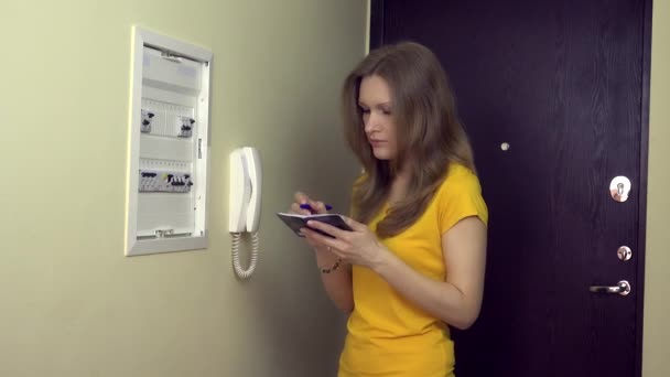 金髪の女性ノートを見て、自宅の電源コントロール パネルでスイッチをオンに — ストック動画