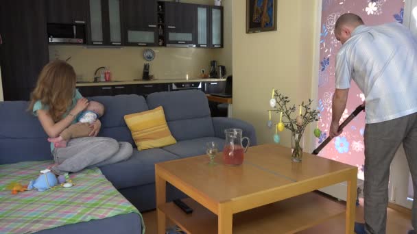 Mutter hält schlafendes Baby auf Händen Staubsauger nach Hause. 4k — Stockvideo