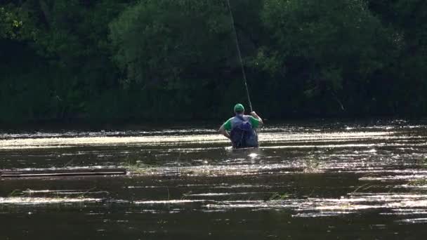 Pescador com vara de vara embora rio de água selvagem profundo para a margem distante . — Vídeo de Stock