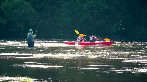Pescatore uomo pesca e sportivi attivi persone con canoe kayak sul fiume . — Video Stock