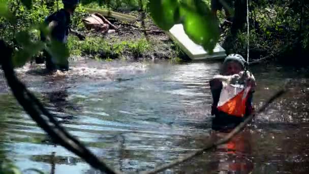 Extreme sportsmen swimming in swamp water. — Stock Video