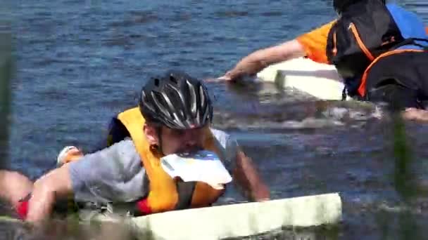 Orienteering competizione sportsman tenere mappa in bocca galleggiare sull'acqua . — Video Stock