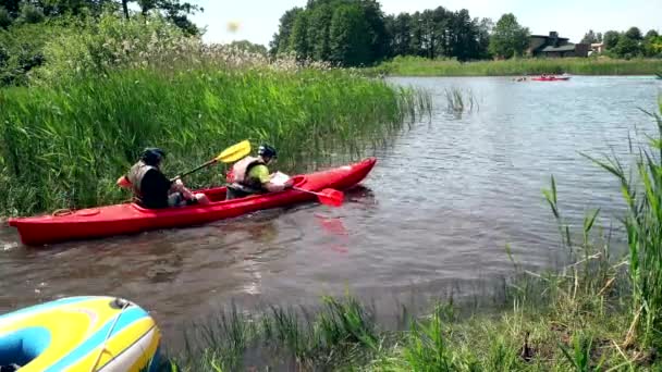 Mensen hebben plezier met handmatig watertransport op het meer. — Stockvideo