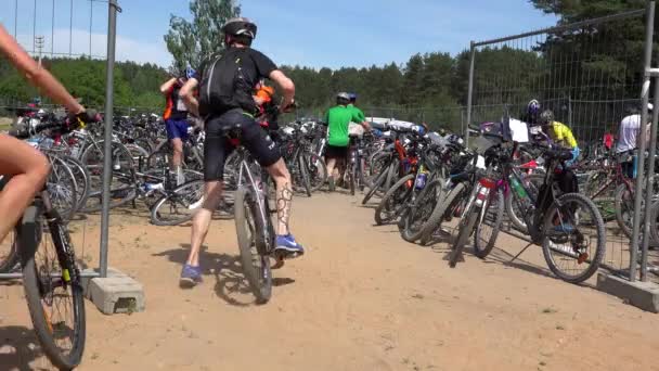 Las personas en ropa deportiva dejan bicicletas en el aparcamiento — Vídeos de Stock