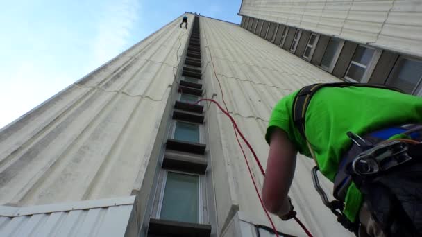 Fearless guy descend down from high skyscraper and service staff care safety — Stock Video