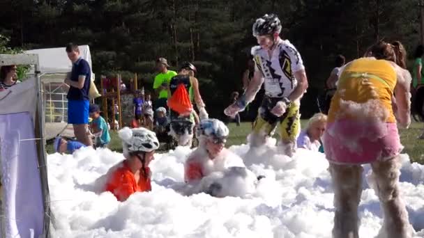 La gente feliz se divierte en espuma artificial después de terminar la competición deportiva — Vídeo de stock