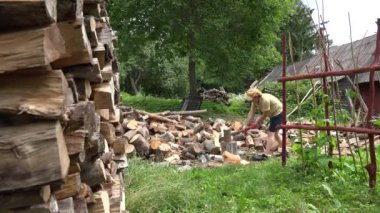 adam ahşap bir diğer ahşap günlük yarda sonra balta ile bölün. 4k